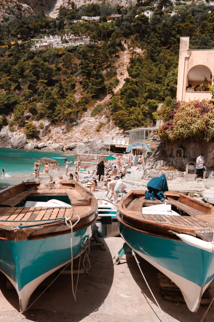 Marina Piccola beach. blue water and blue and white wooden boats in foreground