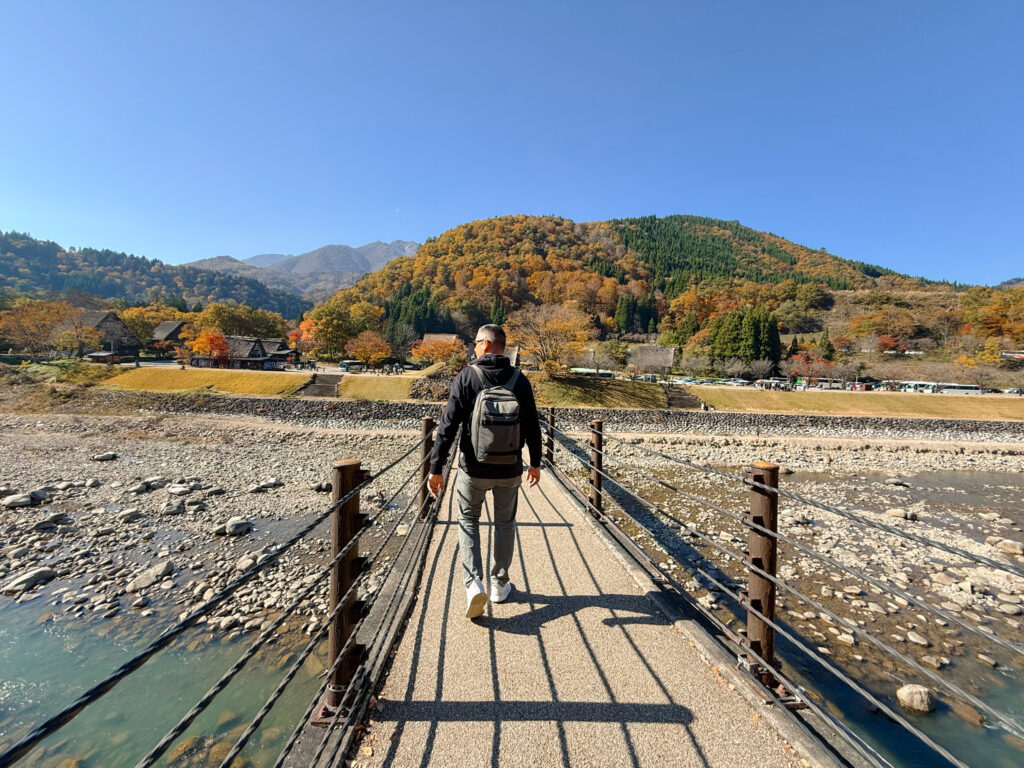 Mike crossing the river with the suspension bridge in Shirakawa-go