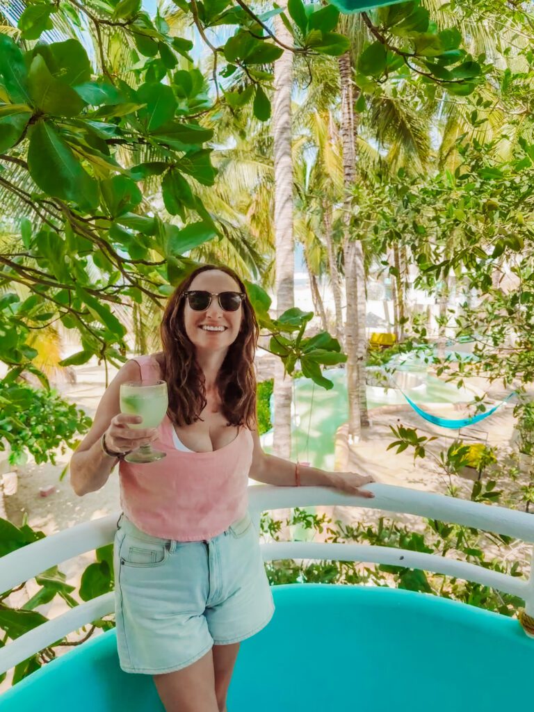 kelly enjoying a drink on the balcony of our room at azul pitaya beachfront hotel in sayulita, mexico