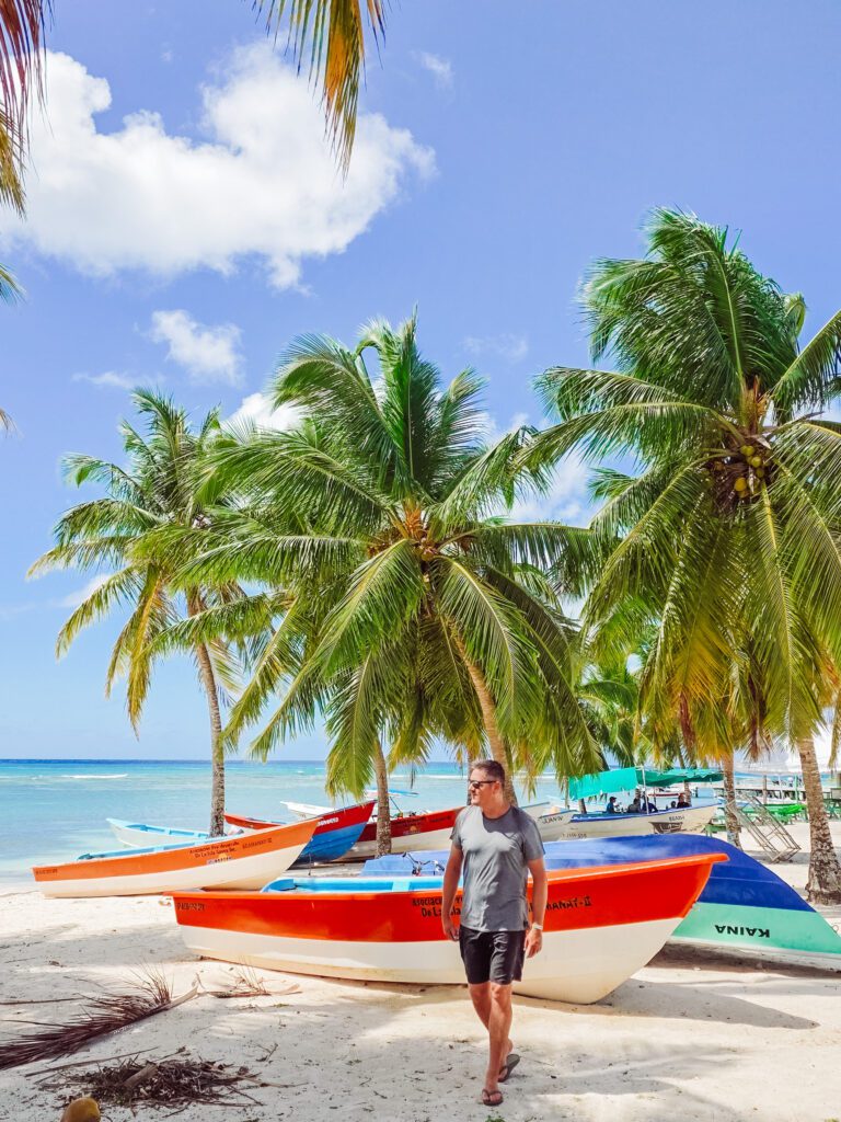mike on the beach at saona island with colourful boats