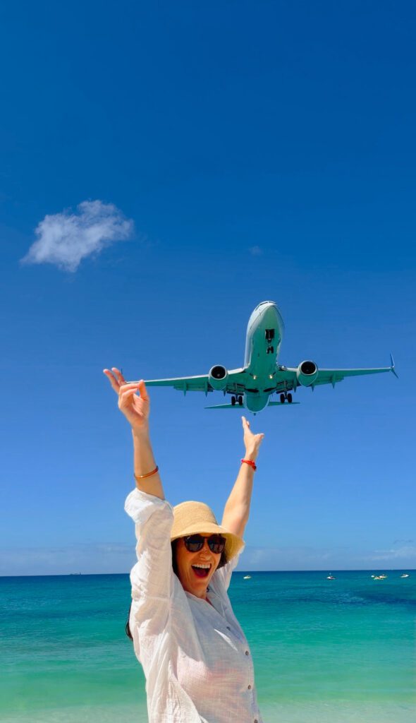kelly with a plane landing over head on maho beach st maarten