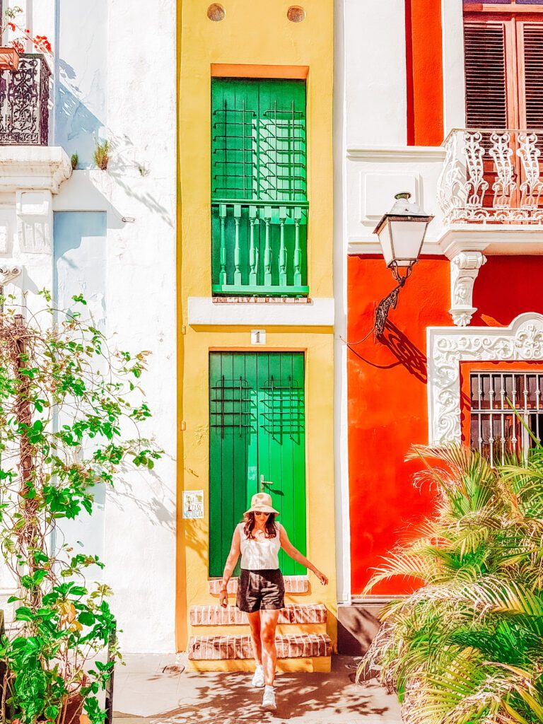 kelly walking the colourful streets of San Juan, infront of the tiny house