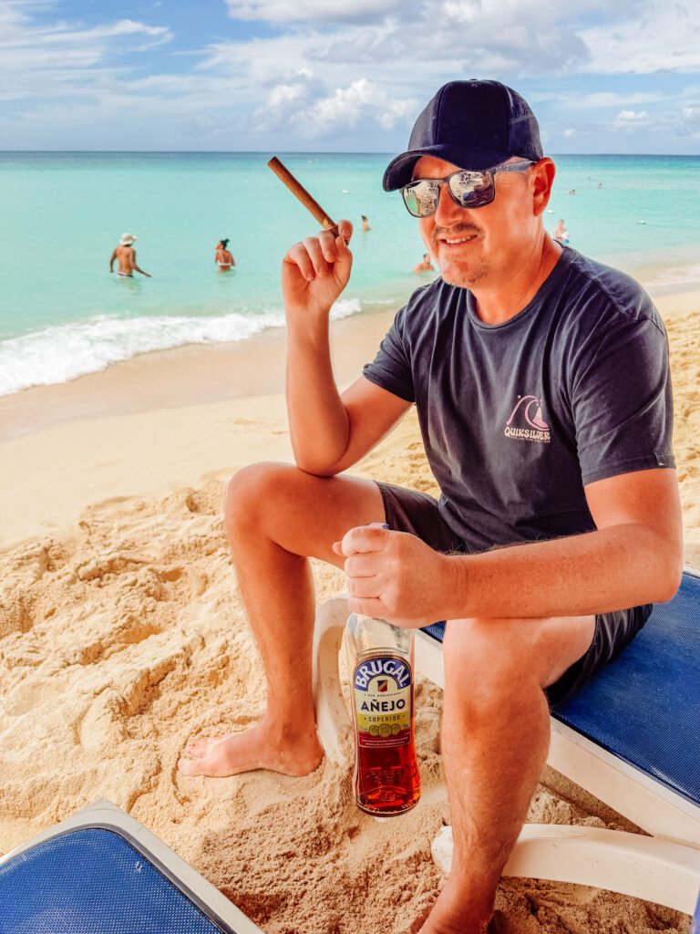 mike with cigar and beer at the dominicus beach, bayahibe, dominican republic