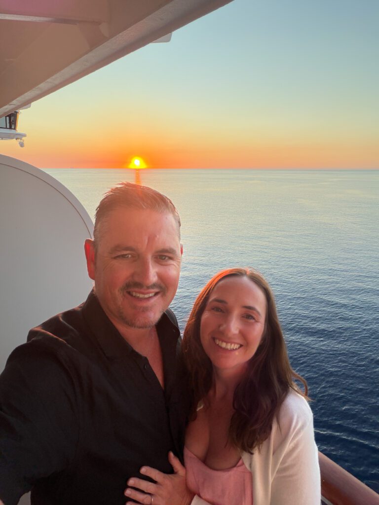 mike and kelly passport nomads on the balcony at bahamas sunset with msc cruise