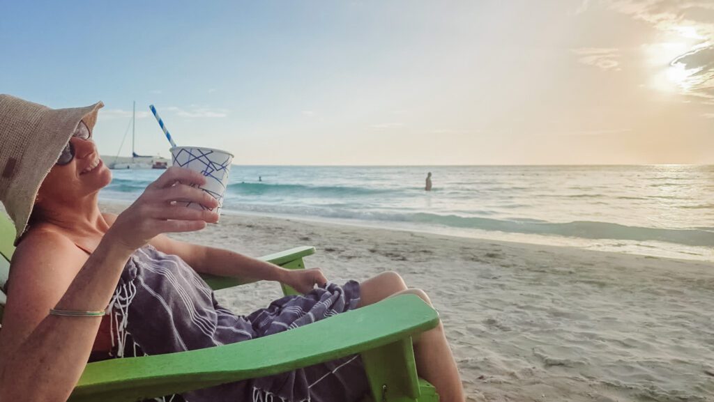 pina colada in the sand and swimming at sunset on seven mile beach at negril jamaica