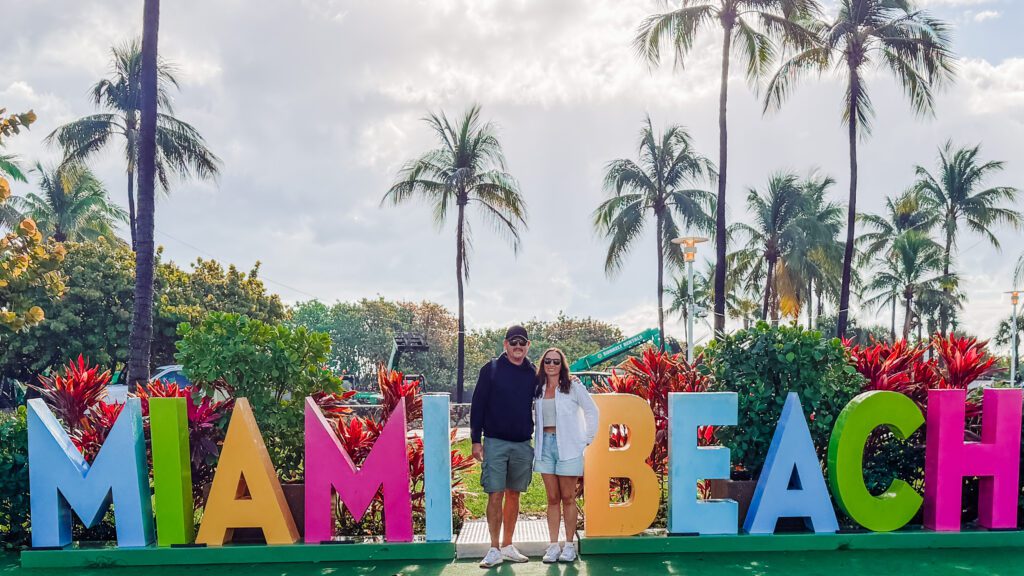 kelly and mike at the miami beach sign