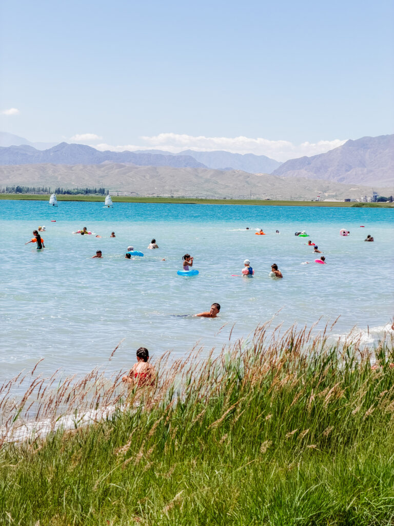 people swimming at the north shore of issyk-kul lake